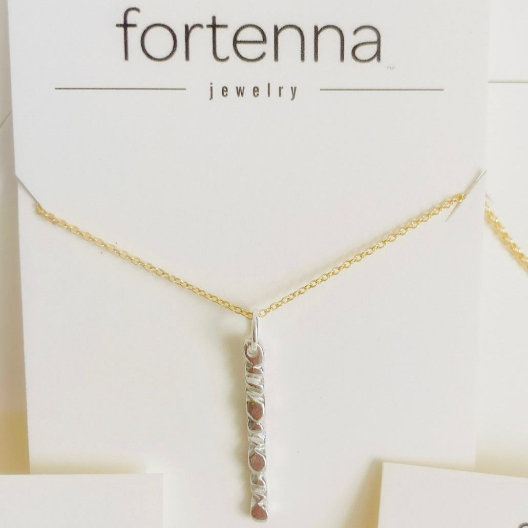 A beautiful mixed metals piece. The 1” vertical bar is a handcarved sterling silver design providing texture and visual detail. Tumbled for a lightly polished look. Comes on an 18” 14k gold-filled chain.