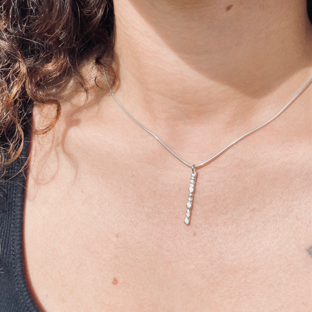 The sterling silver 1" bar is a handcarved fortenna™ design providing texture and visual detail. Tumbled for a lightly polished look. Comes on adjustable 16-18" sterling silver snake chain.