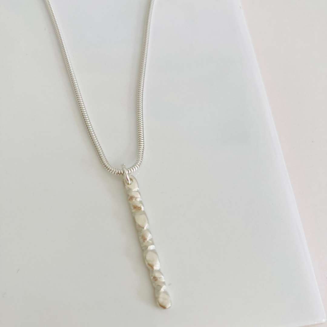 The sterling silver 1" bar is a handcarved fortenna™ design providing texture and visual detail. Tumbled for a lightly polished look. Comes on adjustable 16-18" sterling silver snake chain.