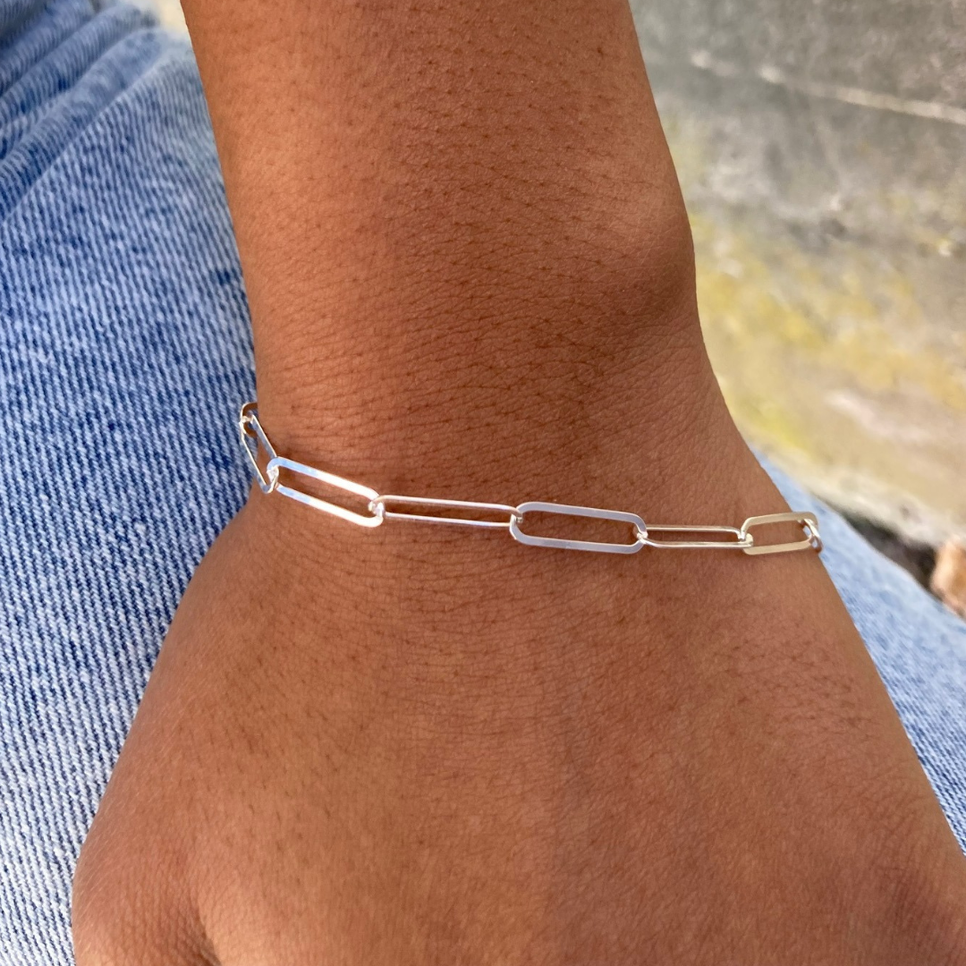 This version of a paperclip bracelet is a sterling silver oval cable chain with a sleek toggle clasp also sterling silver.